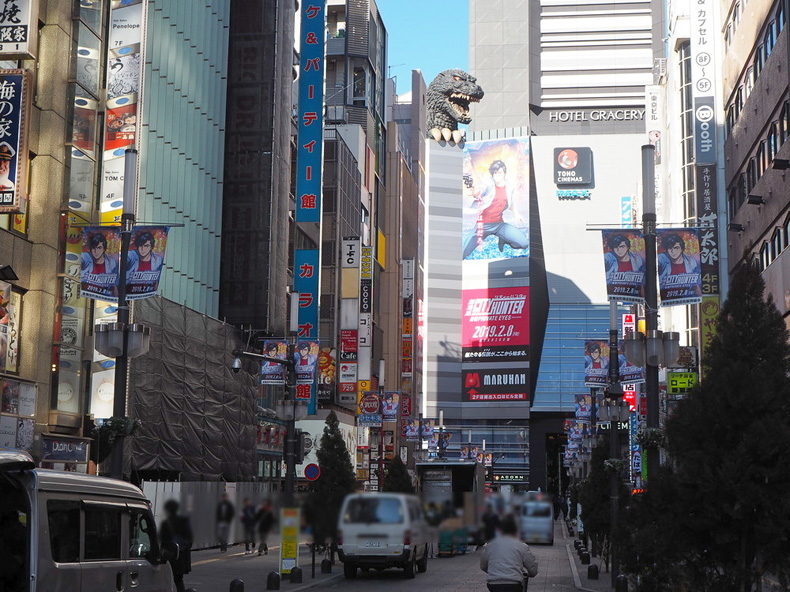 新宿西口駅へ向かう途中の新宿の町並み シティーハンター映画のポスターなど販促品が至る所に掲示されている
