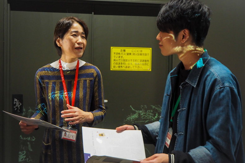 デジタル展示の企画担当・北村さんにインタビューをおこなう編集部員
