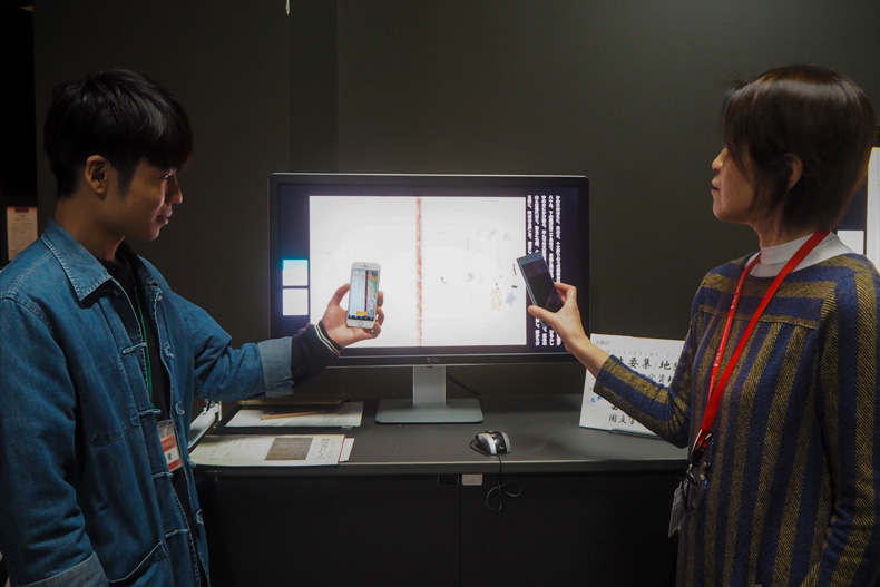 デジタル展示の企画担当・北村さんとともにAR展示を見学する編集部員